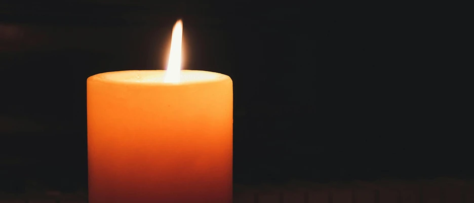 Symbolic image with a burning candle as a sign of mourning