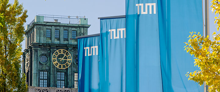TUM-Fahnen wehen im Innenhof, im Hintergrund der Thiersch-Turm.