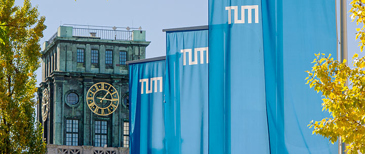 Thiersch-Turm vom Innenhof der TUM aus gesehen mit TUM-Flaggen davor TUM-Fahnen wehen im Innenhof, im Hintergrund der Thiersch-Turm.